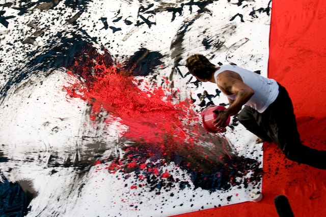 赤い墨を白紙にぶちまける長渕剛。その豪快さは、彼の人生やサウンドそのもの。