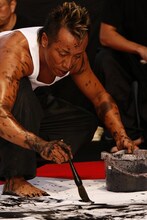 全身のみならず、口の中まで墨を浴びた長渕剛。実際に詩画を書き始める直前まで、何を書くかは決めないという。