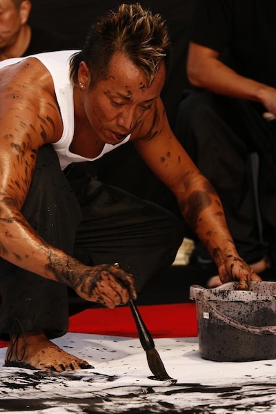 全身のみならず、口の中まで墨を浴びた長渕剛。実際に詩画を書き始める直前まで、何を書くかは決めないという。