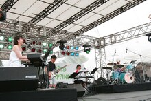 月桂冠のCMソングとして話題の「こんにちは またあした」で幕を開けたコトリンゴのステージ。サポートに坂田学と村田シゲ（□□□）を迎え、澄んだ歌声でゆったりとした空気を作りだした。