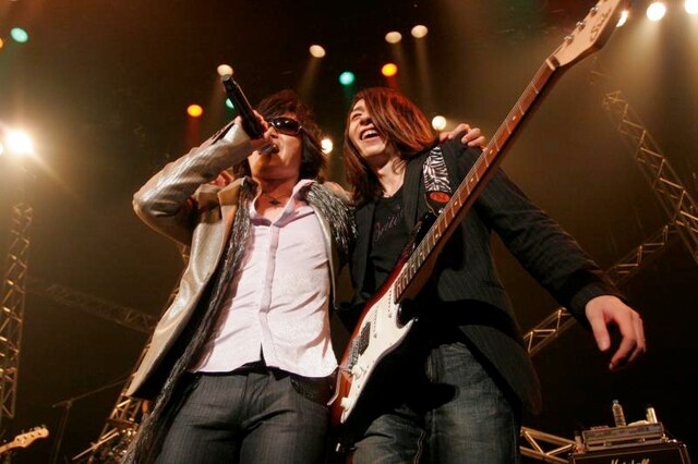 RYO（G/写真右）と肩を組み熱唱するTOSHI（左）。