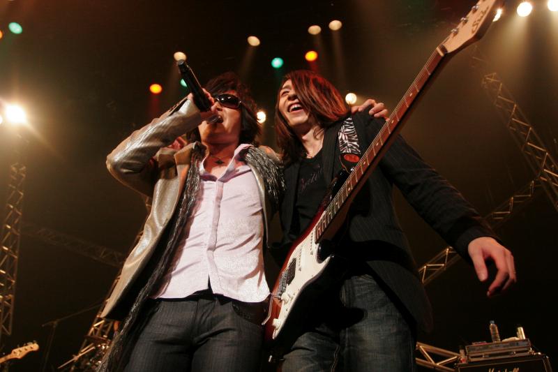 RYO（G/写真右）と肩を組み熱唱するTOSHI（左）。