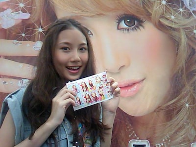 完成したプリントシールを手に、達成感いっぱいの笑顔を見せるMay。