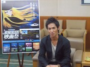 映画祭ポスターの横でくつろぐ中孝介。ちなみに映画が公開される9月9日はシングル「空が空」の発売日でもあるので、ファンはCDを買って劇場に駆け付けよう。