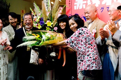 故・赤塚不二夫の娘であり、展示会の企画を担当した赤塚りえ子に花束を手渡すmisono。