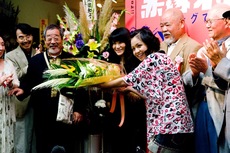 故・赤塚不二夫の娘であり、展示会の企画を担当した赤塚りえ子に花束を手渡すmisono。