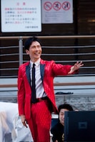 左腕を水平に伸ばす郷。