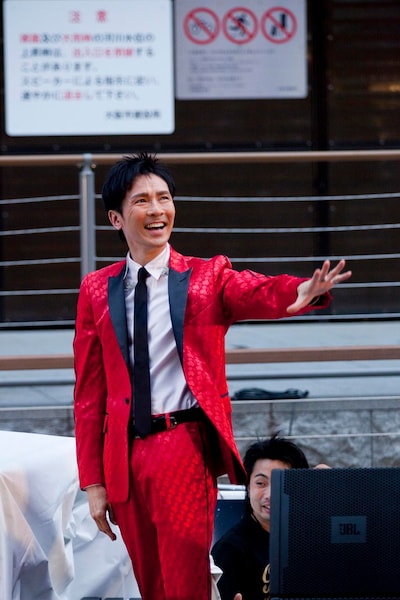 左腕を水平に伸ばす郷。