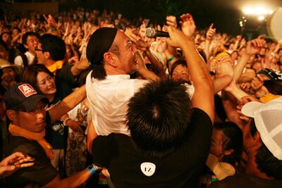 若い観客の中にダイブして手荒い歓迎を受ける61歳の泉谷。