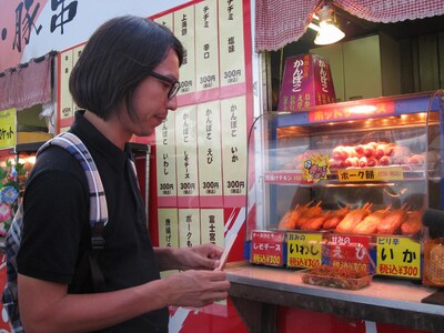 写真は本編映像より。サービスエリアの醍醐味、ホットスナックを前にして、静かにテンションが上がるフルカワトオル35歳。