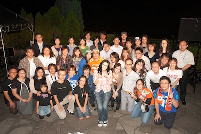 当選したラッキーなメガネっ子カップルとともに、誕生日の記念撮影を行うアンジェラ。