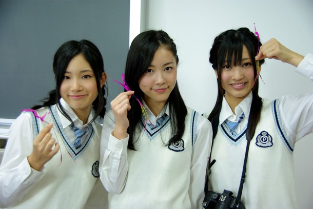 写真部部長の矢神久美（写真左）と部員の新海里奈（右）とともに、線香花火を持つ松井珠理奈（中央）。