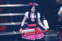 ショルダーキーボードを背負ってニッコリとほほえむアイラ。