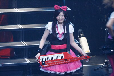 ショルダーキーボードを背負ってニッコリとほほえむアイラ。