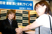 先頭に並んだファンと握手をする小室哲哉。