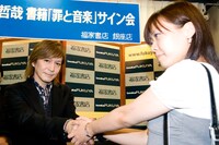 先頭に並んだファンと握手をする小室哲哉。
