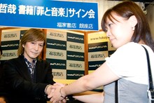 先頭に並んだファンと握手をする小室哲哉。
