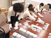 ジャケットと封入カードを並べ、次々と刻印していく4人。