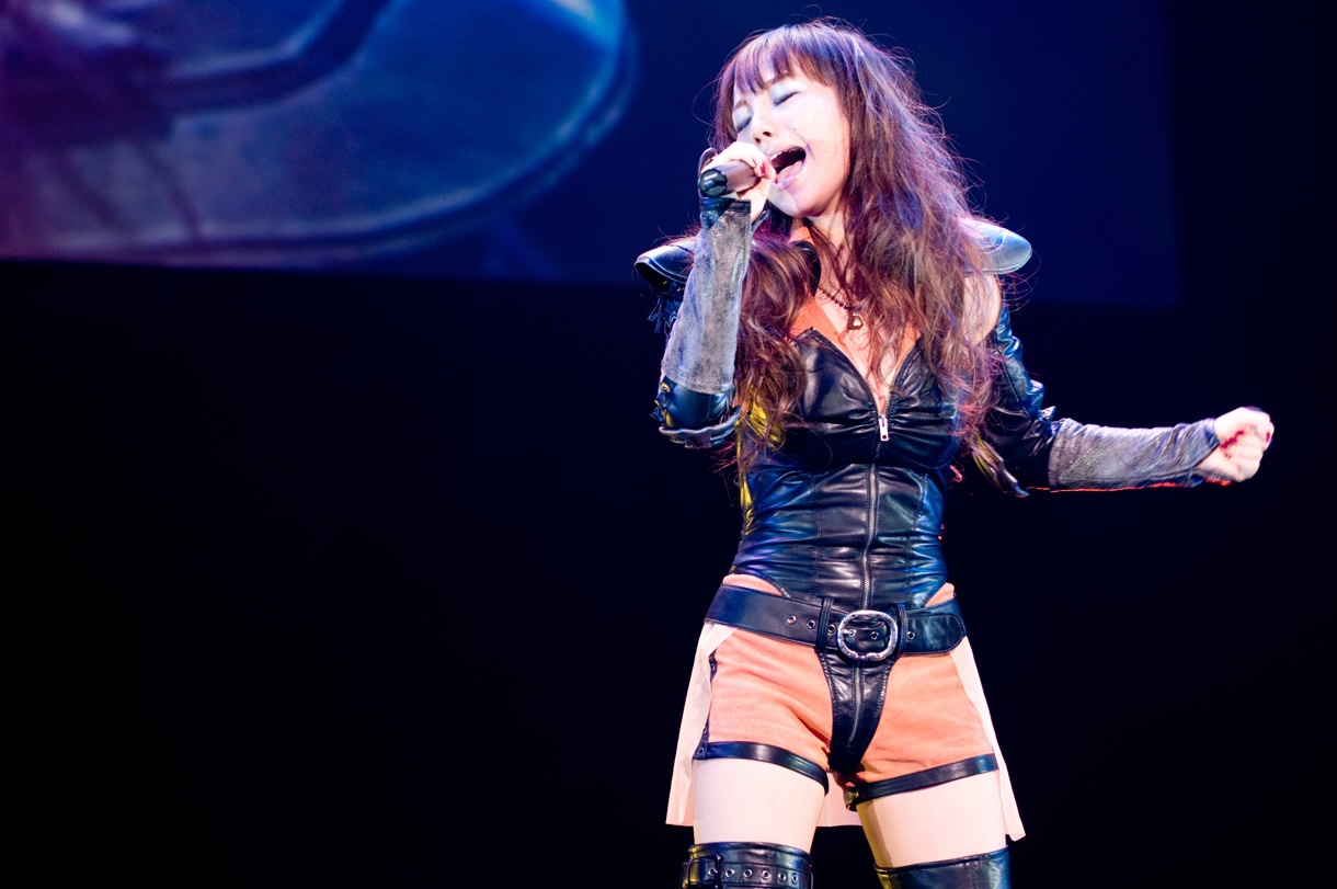 マミヤの衣装でイメージソングを歌う谷村奈南。「ゲームが発売されたらすぐに買いに行って私もやりたいなと思ってます。イメージソングを歌えることを誇りに思っています」。