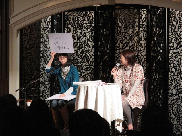 頭上にフリップを掲げて知られざるエピソードを次々と話すつじあやの（写真左）。