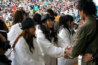 ファンと握手するAKB48のメンバー。写真左から板野友美、峯岸みなみ、渡辺麻友。