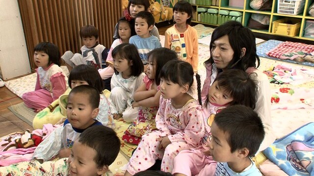 女の子2人を膝に乗せ、父親のように穏やかな表情を浮かべる“じむ先生”。