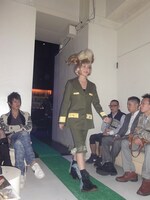 軍服のようなスーツのような、不思議な洋服をさらりと着こなすMayとそれを見つめる観客。