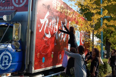 メッセージを書き込む女性ファン。トラックの運転を務めたドライバーは、「とにかく九州男のファンは熱血で礼儀正しいファンが多くて感心しました」とコメントした。