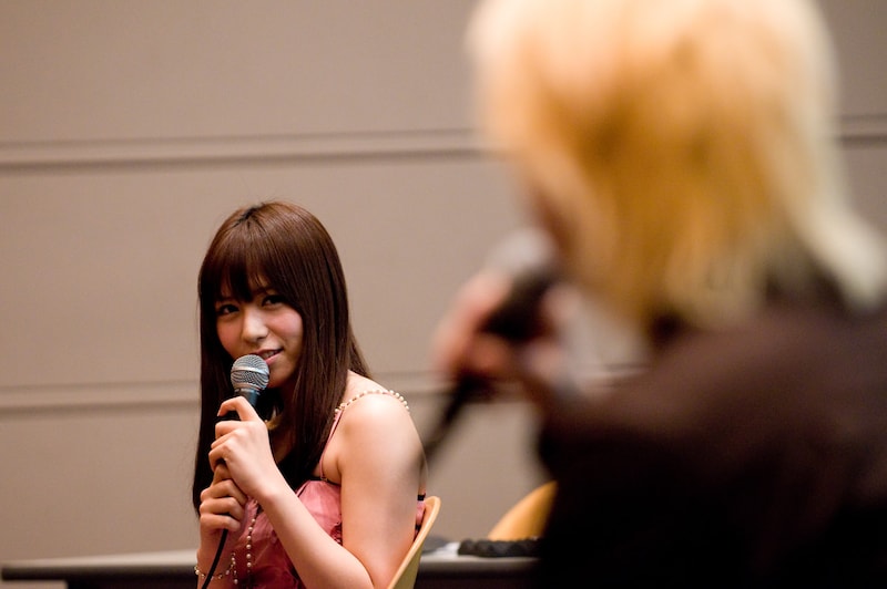 津田（写真手前）の「今後、Twitterをどうしていきましょうかね？」という問いに対し、力強く「私が引っ張っていきましょうかね！」と答えた河西（奥）。イベント終了後の夜、彼女は「今日の漢字はもちろん..........☆金髪☆ですょね(｀▽´ゞ」とつぶやいている。