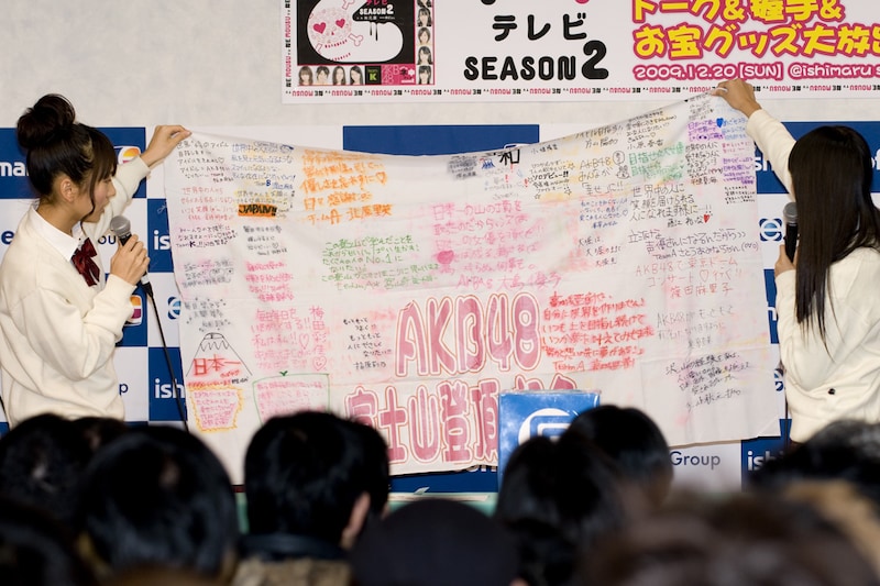 富士登山メンバーに手渡された、AKBメンバーのメッセージ入りフラッグ。北原は「ゆきりん（柏木由紀）は雨女なんですけど、ゆきりんのDVDを再生したら雨が降り始めた」と、富士登山時のエピソードを明かした。