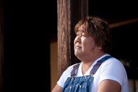 目を細めて遠くを見る石塚英彦。