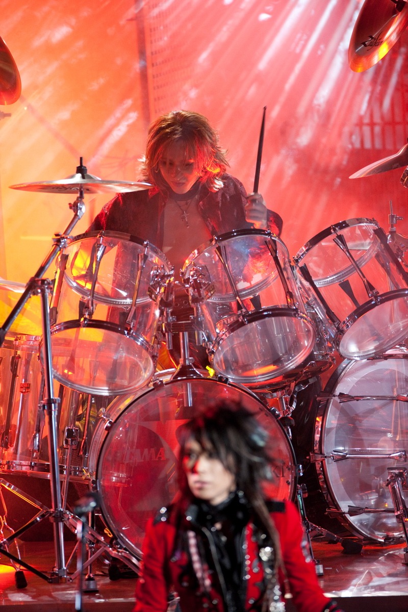 ドラムを叩くYOSHIKI（写真前方はHEATH）。