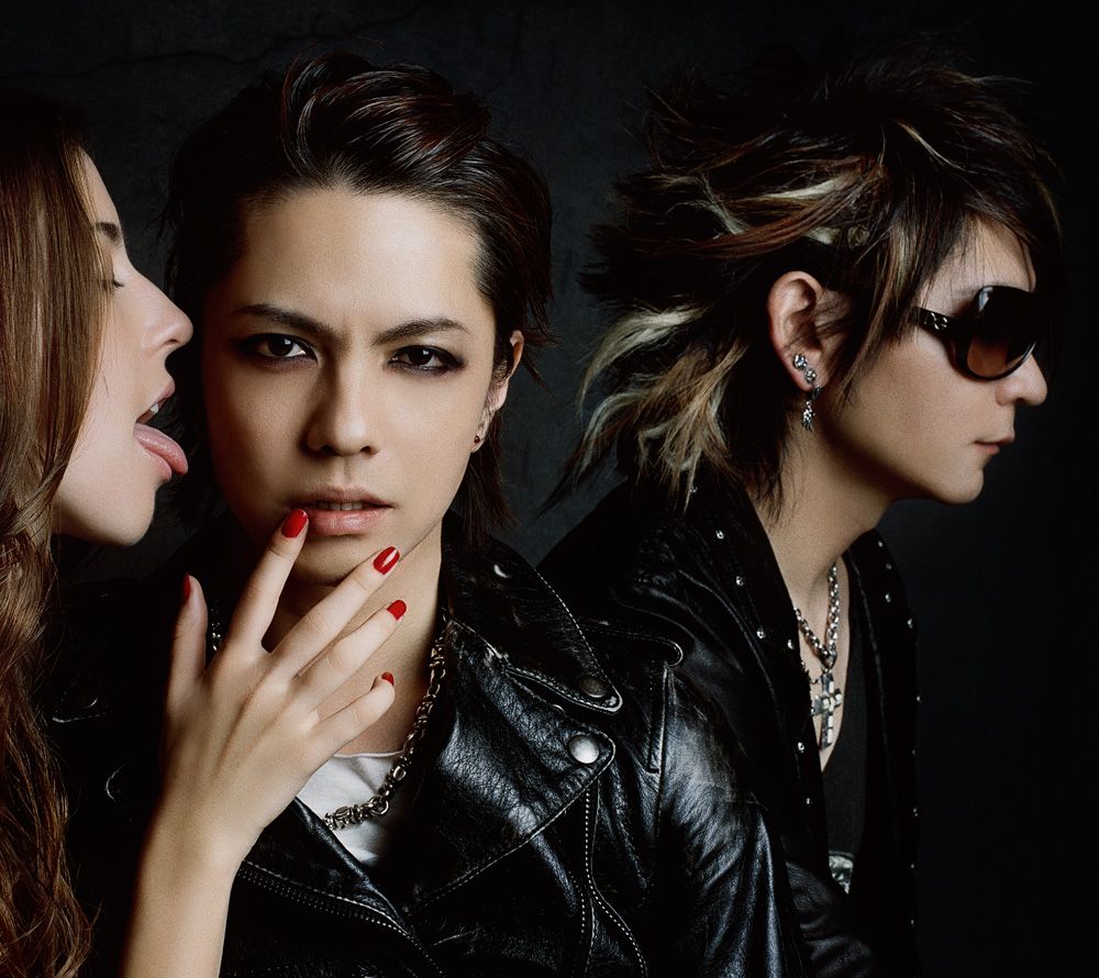 美女に頬を食べられそうになっているHYDE（写真中央）の脇でクールに佇むK.A.Z（写真右）。
