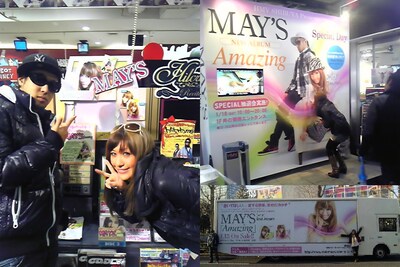 自分たちの作品を紹介する看板やポップ、巨大アドトレーラーを前にうれしそうなMAY'Sの2人。なお「Amazing」は1月12日付けのオリコンデイリーチャートで初登場3位を記録した。