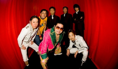 アーティスト写真も今回の発表にあわせて更新。こちらもロゴ同様アニバーサリーイヤーにふさわしいゴージャスな雰囲気に。しかしバイト君（大道具）だけは以前と変わらないTシャツ＆ジーパン姿だ。