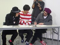 カメラに向けて自分が描いたものを見せるJxJx（写真右）。