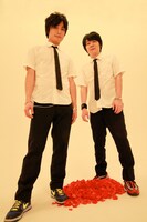 マル（Vo, Prog/写真左）とDie（TB-303, Prog/右）の2人からなるユニット、HONDALADY。足下にはなぜか真っ赤な花びらが。