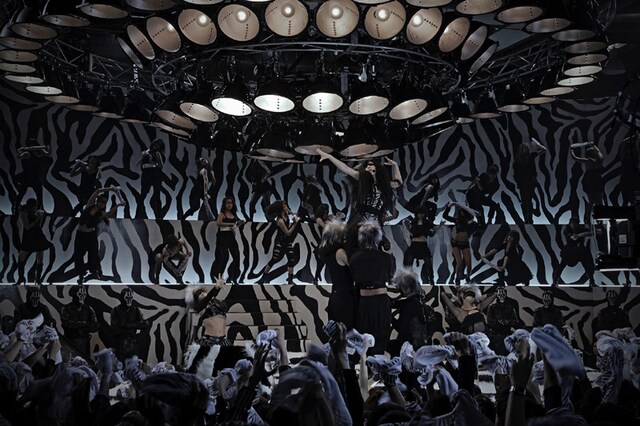 サイケデリックなゼブラ柄のステージで歌うゼブラクイーン。