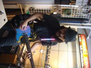 完成したオリジナルギターを試し弾きする対馬祥太郎（Dr）。普段はスティックを握っていることが多いので、この姿は貴重。