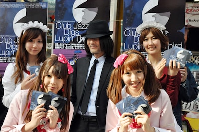 秋葉原のメイドたちと記念撮影をする、次元大介似の男性（写真中央）。