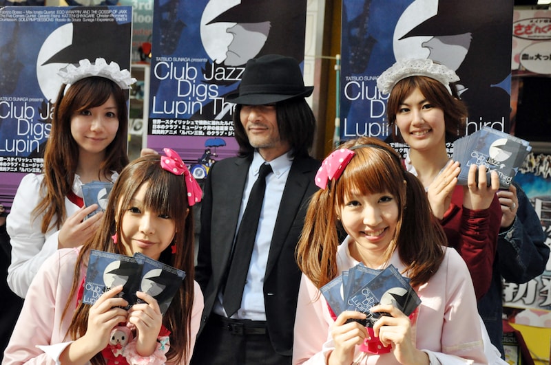 秋葉原のメイドたちと記念撮影をする、次元大介似の男性(写真中央)。