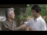 義父のグラスにビールを注ぐ娘婿。