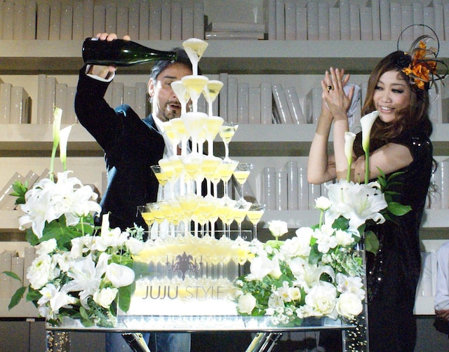 約80個のグラスが積み重ねられたシャンパンタワーに、なみなみとシャンパンを注ぐクリス・ペプラー。JUJUは満面の笑みでその様子を見つめた。