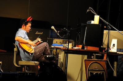 リードギターを録音する民生。トラ目のサンバーストが特徴的なギブソン1959レスポールスタンダードは、ファンにもおなじみのギターだ。頭に着けたデビルホーンヘアバンドもお似合い。