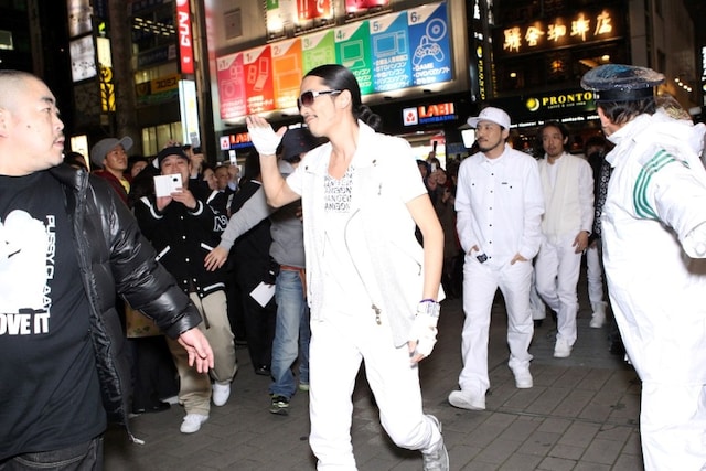 Zeebraを先頭にサラリーマンの聖地・新橋の駅前を闊歩する4人。現場は警備員も出動するほどの人が殺到した。