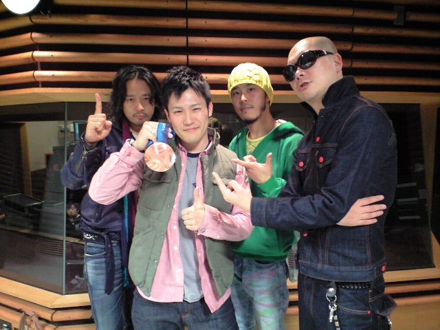 銅メダルを掲げる加藤条治選手とRHYMESTERの3人。