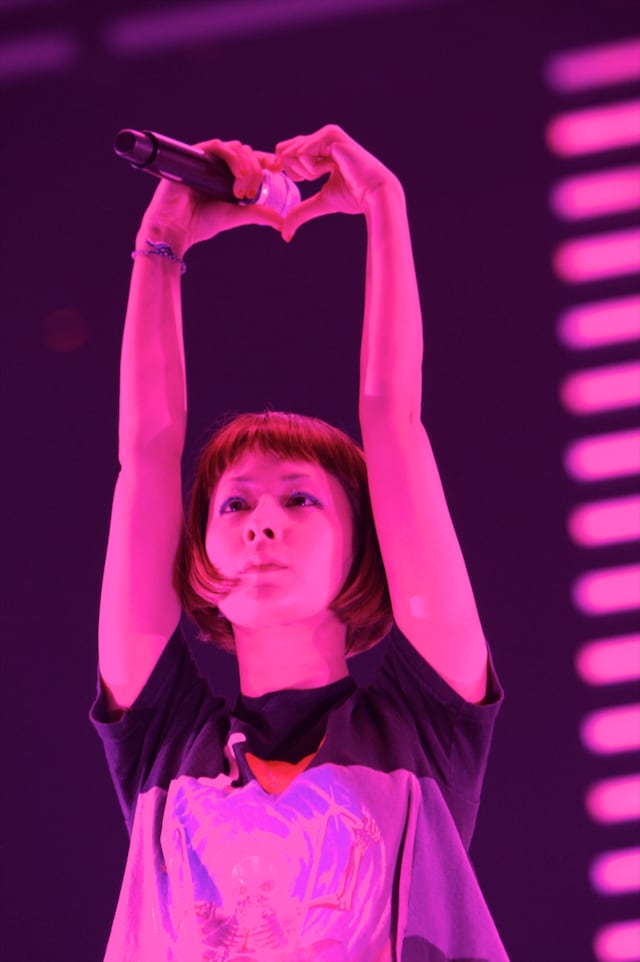 3曲目「マスタッシュ」の終わりには、手で作ったこのハートから客席を覗きこむ仕草をみせた。（photo by Tsukasa Miyoshi）