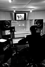 ミキサールームにて。写真上方のモニターには、別室でギターを弾くTAXMANの姿が映し出されている。