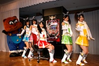 会見では「ぱちんこ必殺仕事人III 15R搭載 竜バージョン」（写真後方）のオススメポイントの紹介も行われた。