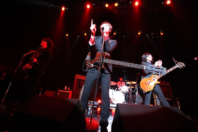 THE BAWDIESのTAXMAN（G/写真左）は、普段のライブどおり缶ビールを持ってステージに登場。ROY（Vo,B/写真中央）とともにハイテンションなMCで場を沸かせた。